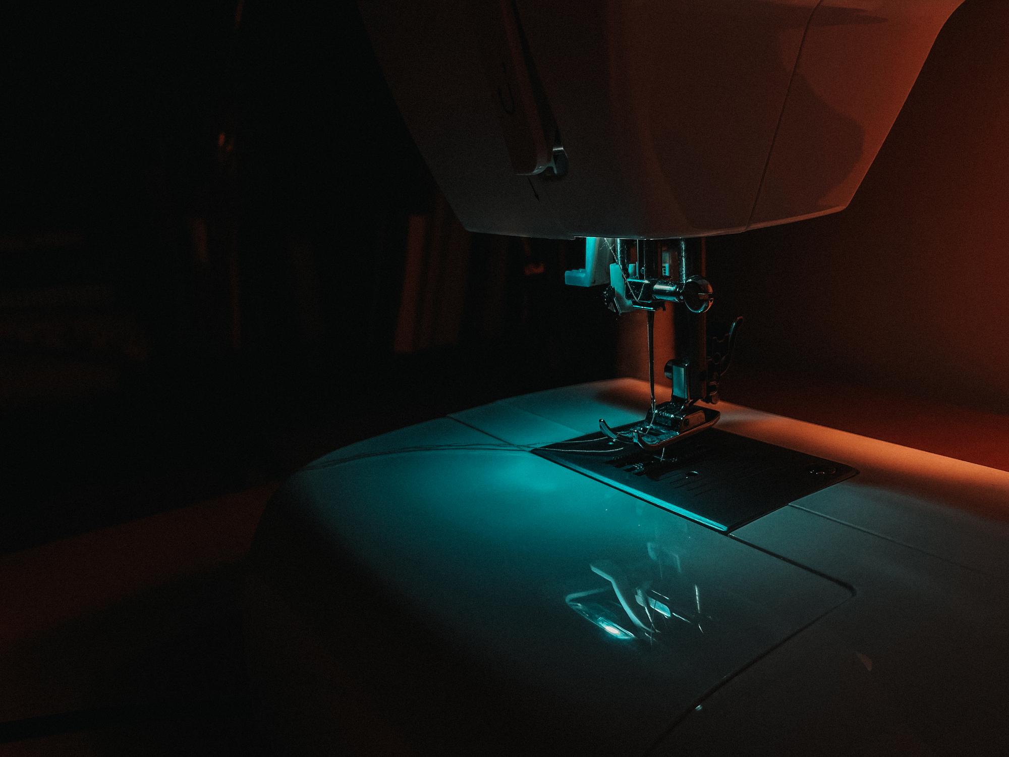 Futuristische Nahaufnahme einer Stickmaschine mit neonblauen Fäden